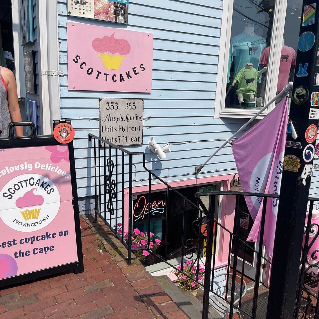 Pink and white sign for Scottcakes bakery on a building exterior.